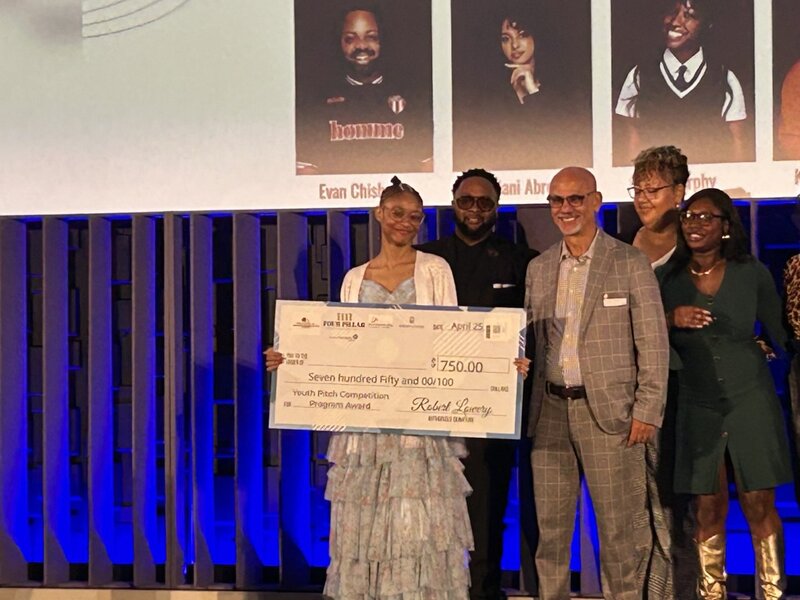 Kendra Davis on stage with the big check